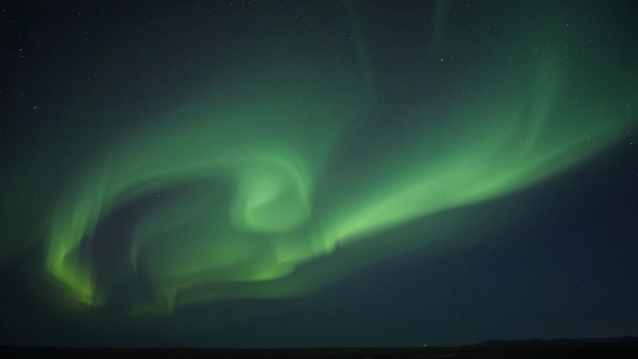 Curling green auroral spiral unfolding into long stream across remote night sky with stars, horizon