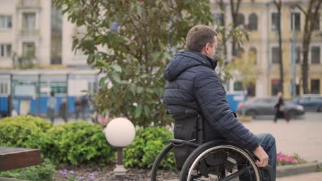 un hombre en silla de ruedas viaja por la ciudad