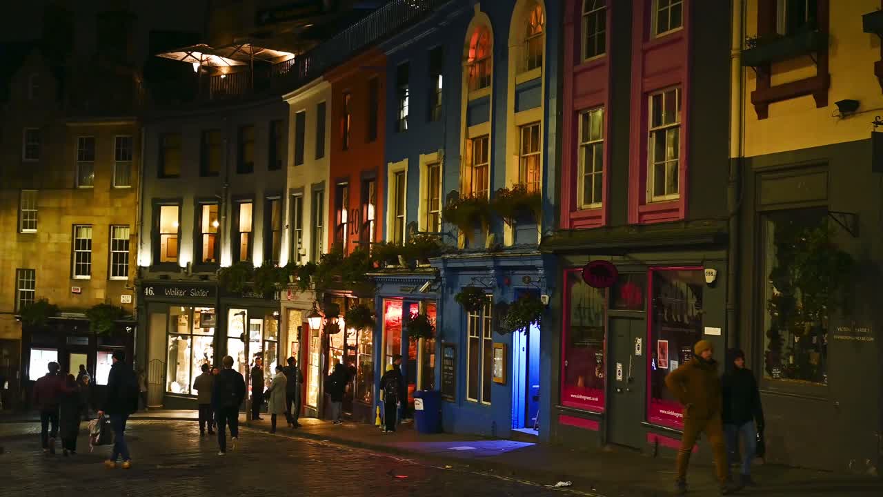 Tourists look at shop window on famous Victoria Street in Edinburgh