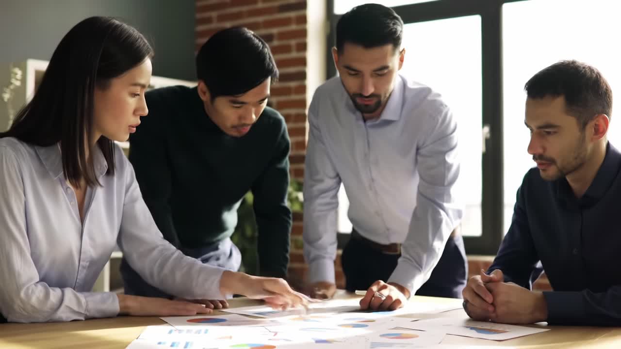 A group of four professionals collaboratively analyzing data and discussing insights during a strategic meeting in a modern office setting, showcasing teamwork and problem-solving