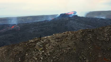 gente en la montaña admirando la vista panorámica del cráter en erupción del volcán fagradalsfjall en islandia