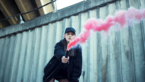 chica agitando una bomba de humo en la cámara. mujer protestando en la calle con una bengala de humo