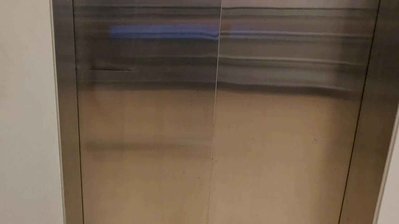 Close-up of elevator button pressing and interior with stainless steel doors.