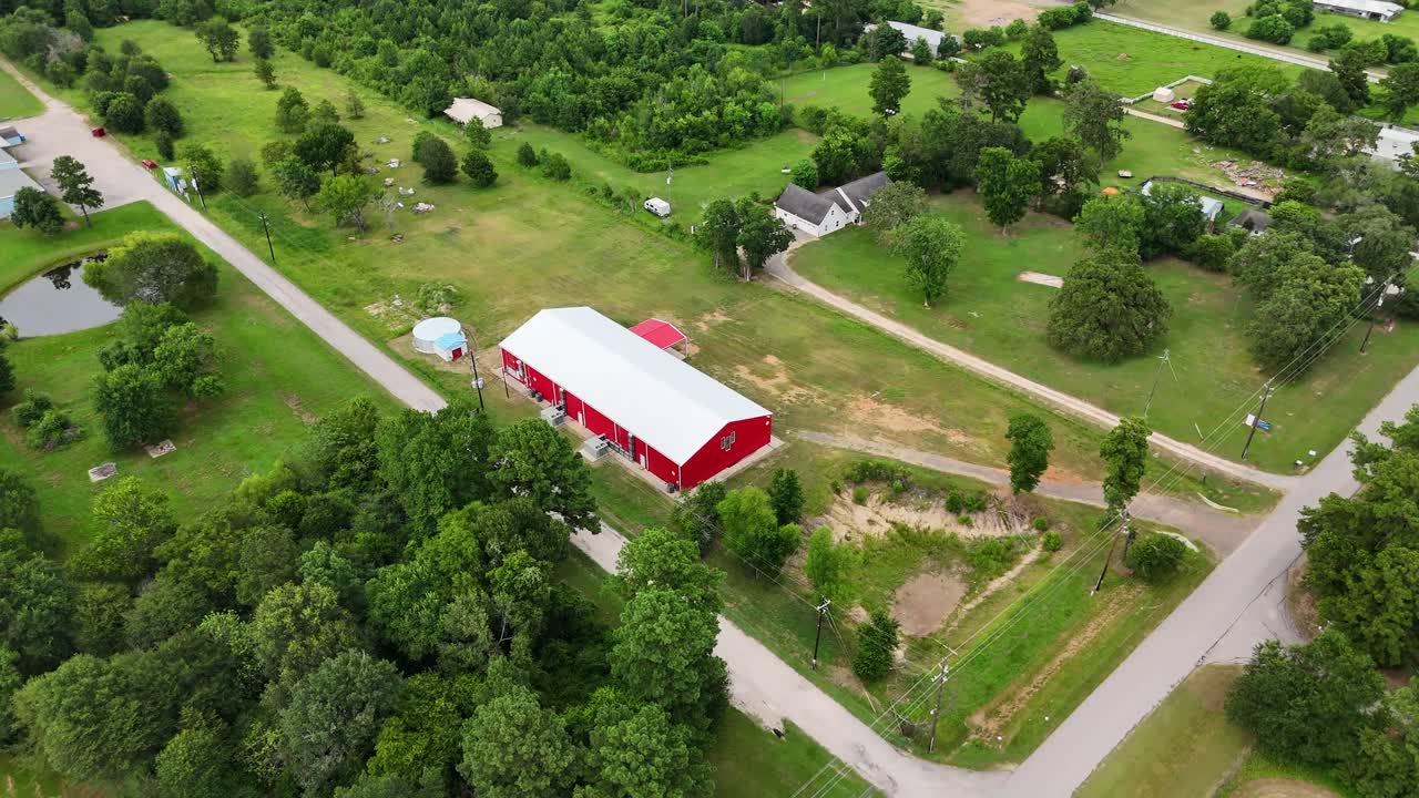 An aerial view of an isolated red barn house.