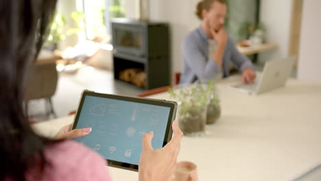 a young asian woman uses smart home app on a tablet