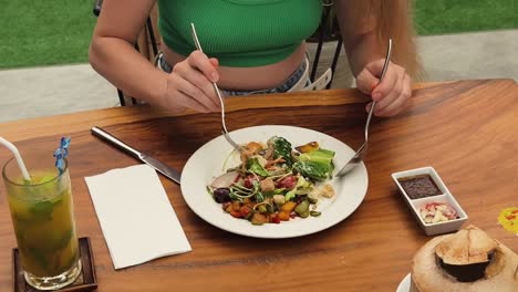 mujer disfrutando de una ensalada en un café al aire libre
