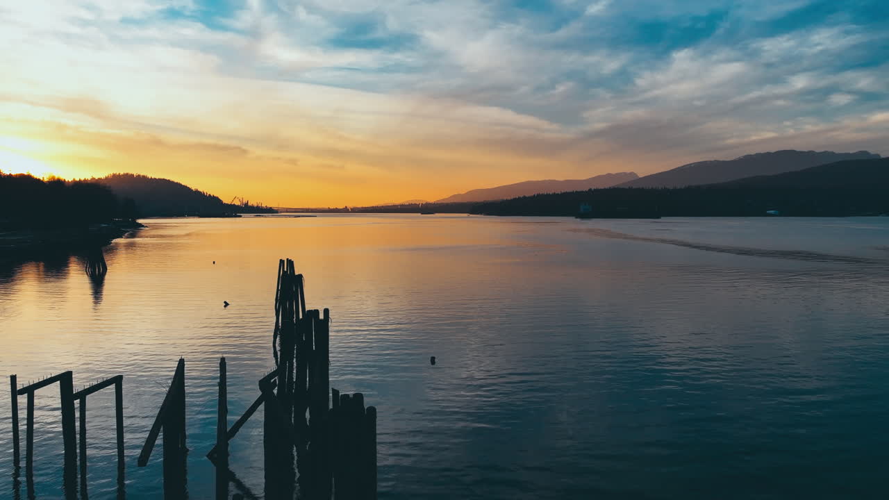 Sunset over a Calm River with Mountains in the Background