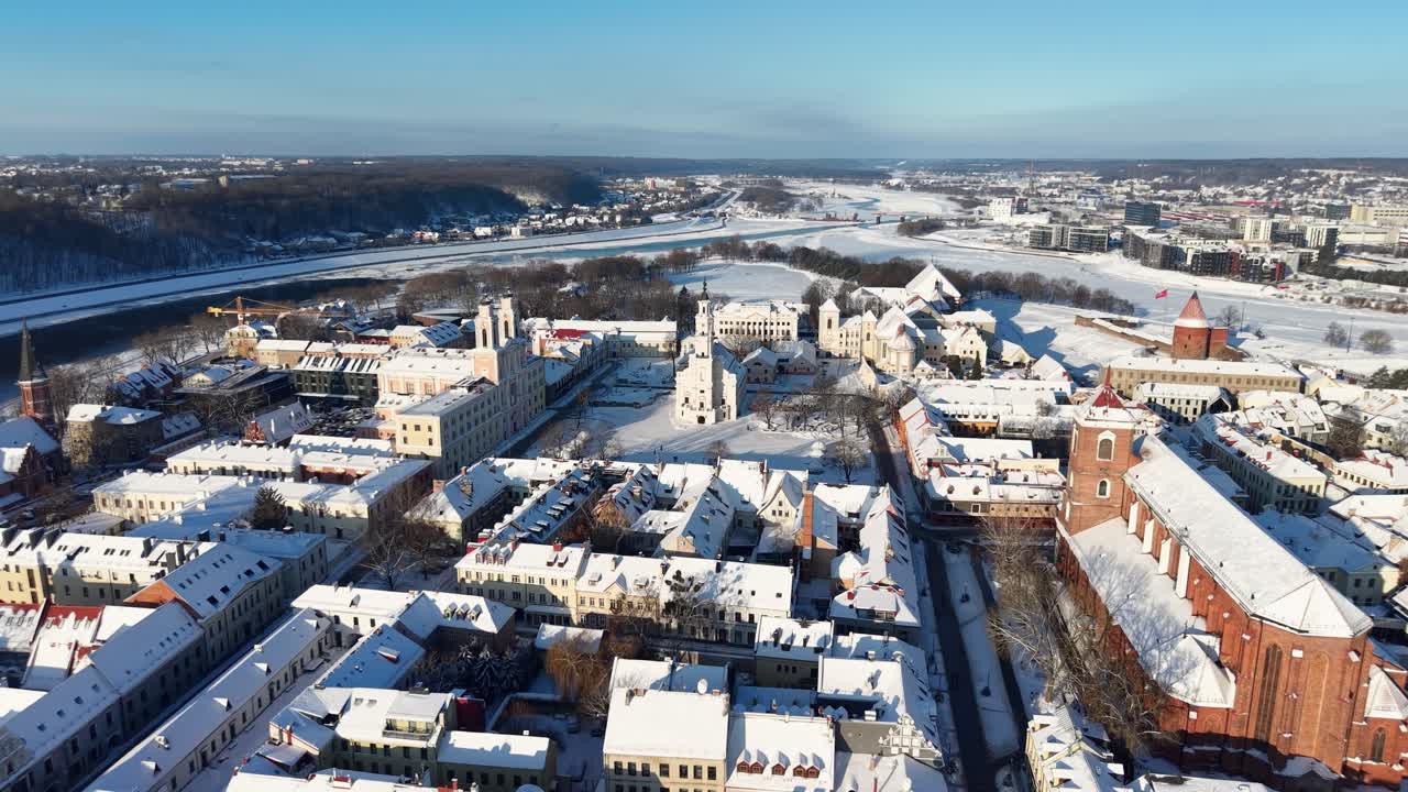 Et fantastisk luftfoto av Kaunas gamleby, Litauen, dekket av snø. Scenen fremhever historisk arkitektur som rådhuset og Kaunas katedral. Fanget i skarpt sollys.
