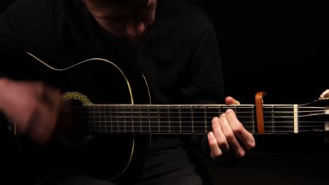 shot of man playing and strumming the guitar