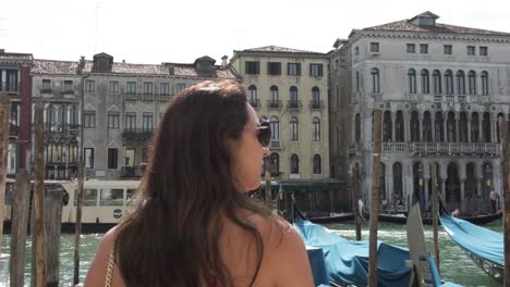 tourist rear view standing on the grand canal pier in venice, italy