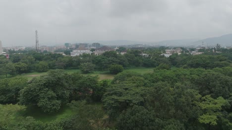aerial - forested area under a cloudy sky, abuja, nigeria, forward tilt up reveal