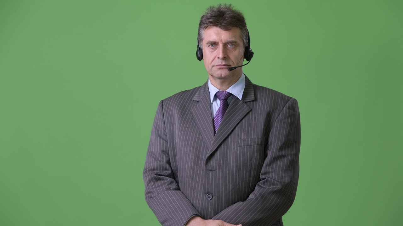 Uomo d'affari maturo e affascinante su sfondo verde