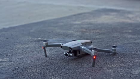 Quad-rotor-drone-taking-off-from-the-ground--close-up