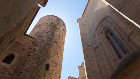 Histórica-Torre-De-Carvajal,-Cáceres,-España:-Torre-De-Piedra-En-Un-Encantador-Callejón---Inclinada-Hacia-Abajo