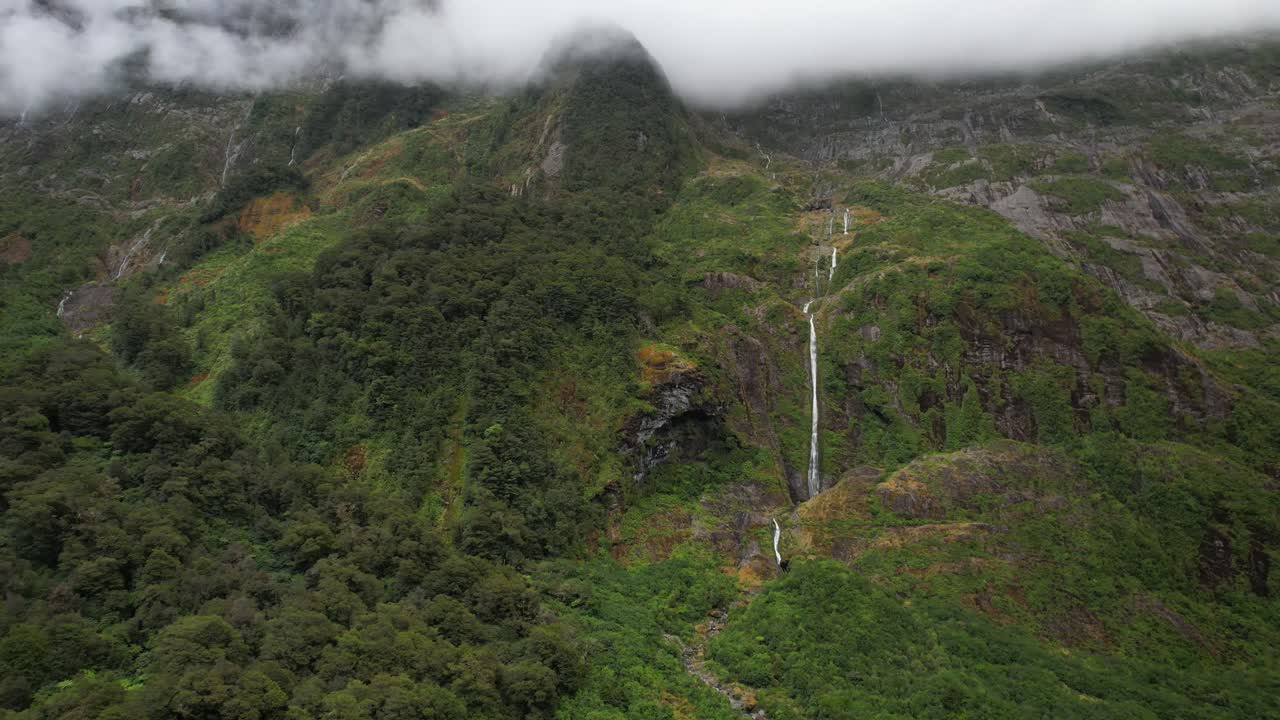 hermosa cascada de alta montaña en el parque nacional de fiordland, nueva zelanda - avión no tripulado