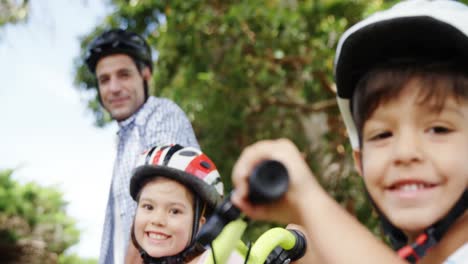 Padre-E-Hijos-De-Pie-Con-Bicicleta-En-El-Parque