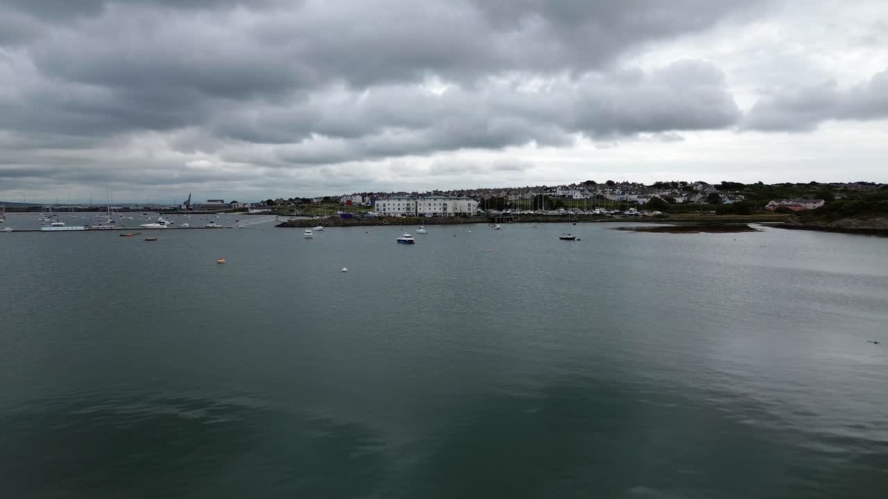 Holyhead town harbour aerial view across yachts boats floating on the bay marina with overcast sky