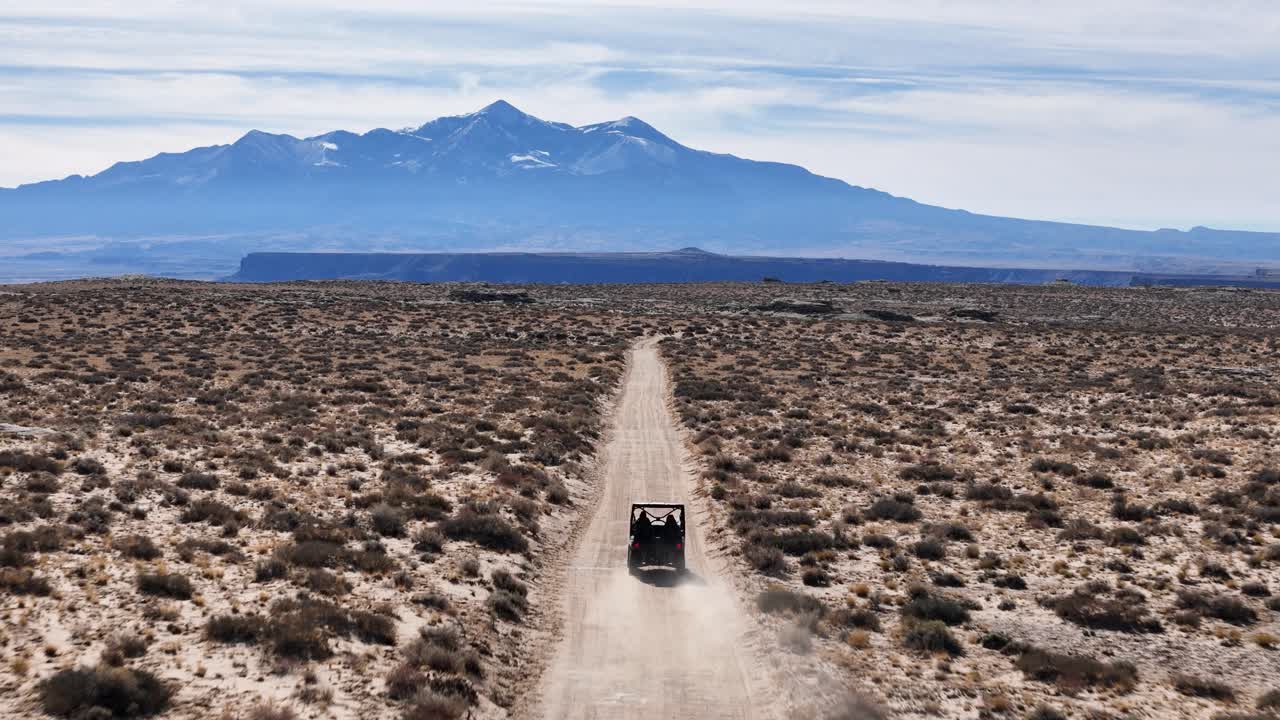 Tracking Drone Shot of UTV Vehicle on Dusty Road in Utah Desert USA