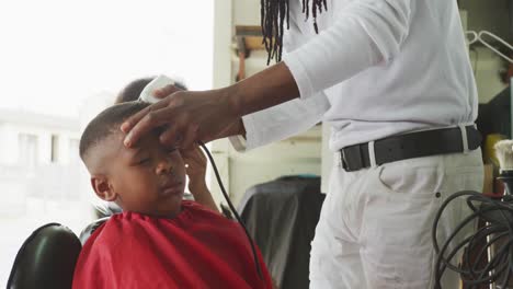 african man cutting african boy hair