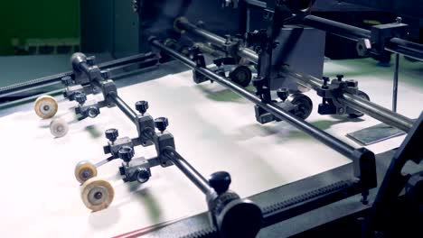 a row of paper sheets is going along the factory conveyor