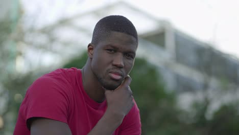 man touching chin, turning head to camera, looking at camera