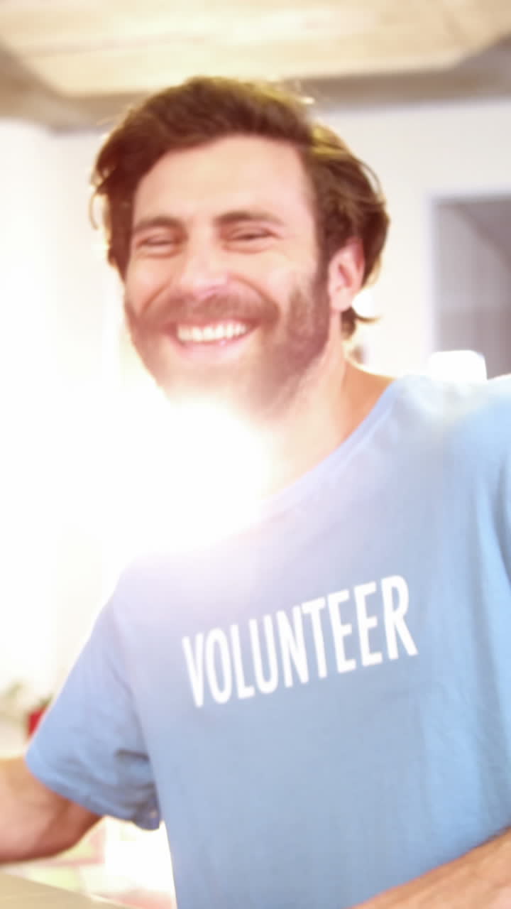 voluntario masculino empacando ropa en una caja de donación