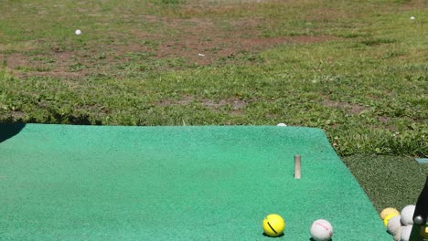 el club de golf golpeando la pelota en la alfombra de práctica