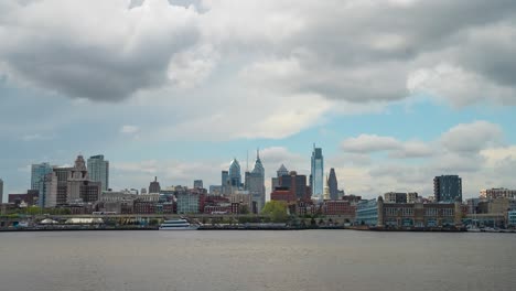 el horizonte de filadelfia en lapso de tiempo con nubes de tormenta moviéndose sobre el tranquilo río delaware