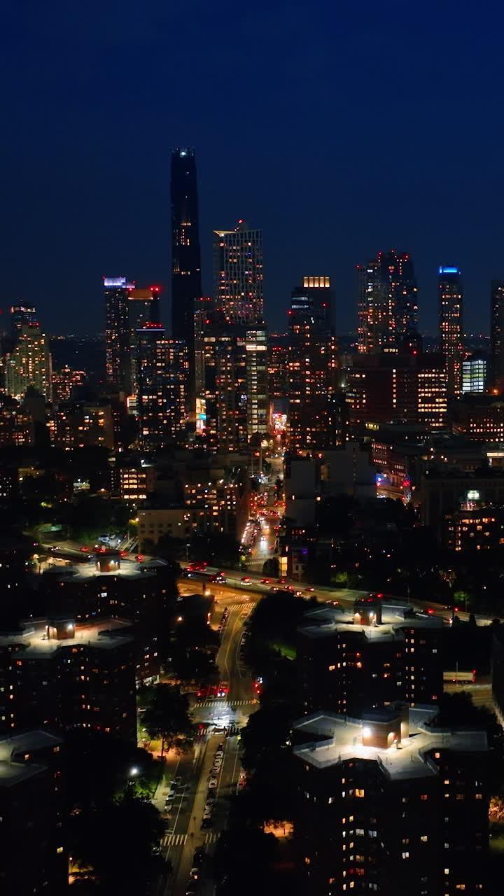 Glossy New York at night. City scenery with lively traffic on roads. Top perspective. Vertical video
