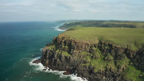 aerial panorama of rocky coastline with green meadows, indian ocean