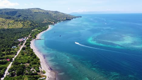 aerial drone view of tourism dive boat cruising around coral reef ecosystem in beautiful turquoise blue ocean of atauro island in timor-leste, southeast asia