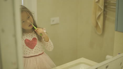 una niña joven cepillándose los dientes en un baño brillante, practicando la higiene oral diaria. ideal para conceptos de salud, rutinas infantiles, higiene y cuidado personal.