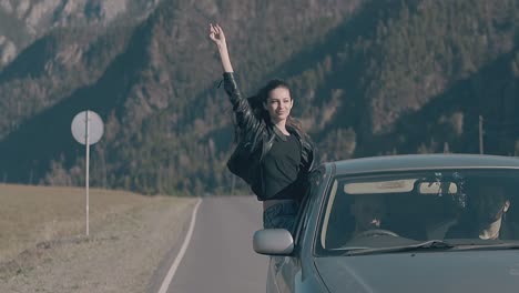 vintage car drives along long asphalt road with happy woman