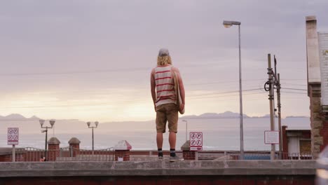 caucasian male surfer holding a wooden surfboard