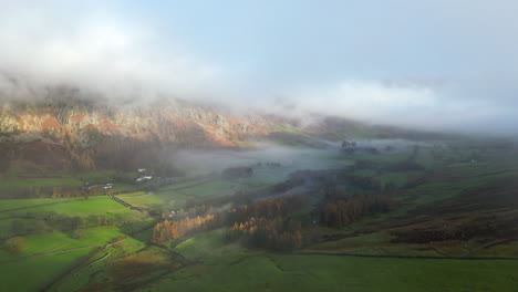 Grünes-Tal-Und-Wolkenverhangene-Berge-Im-Frühen-Herbstsonnenlicht