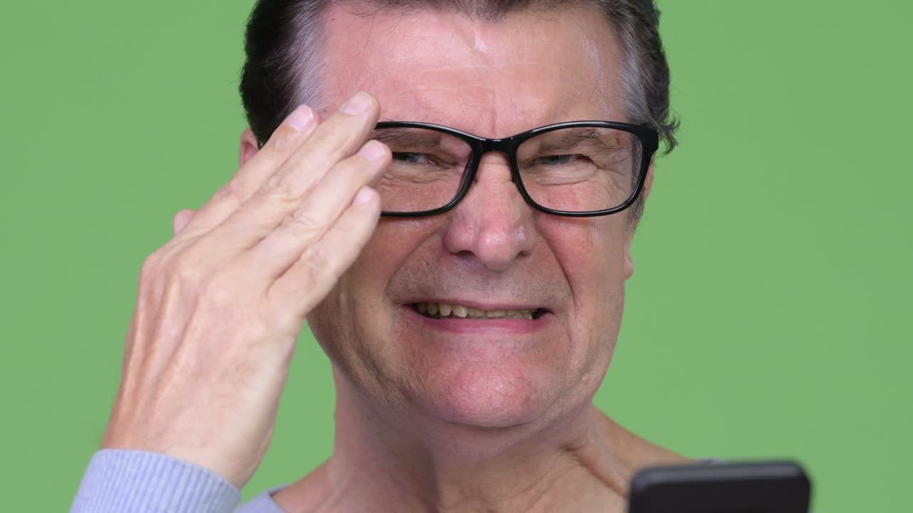 Senior handsome man using phone and getting bad news