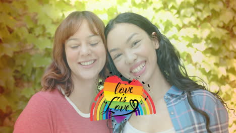 love is love text animation over smiling women embracing with leafy background