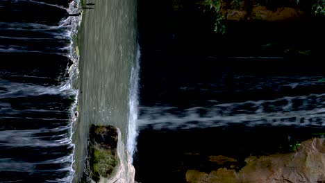 video vertical: pequeña cascada, corriente de agua dulce