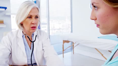 médico chequeando la presión arterial de una paciente