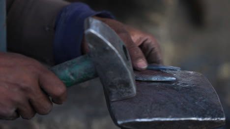 Herrero-Martilla-Una-Herradura-Para-Enderezarla-En-Un-Taller-En-Bamyan,-Afganistán---Cerrar