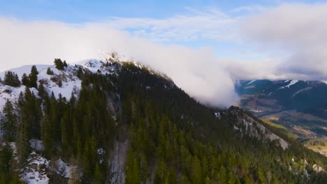 flying to strange falling cloud over mountain valley with snow and pine