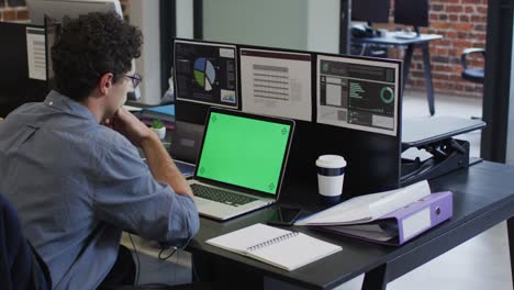 hombre usando una computadora portátil mientras está sentado en su escritorio en la oficina