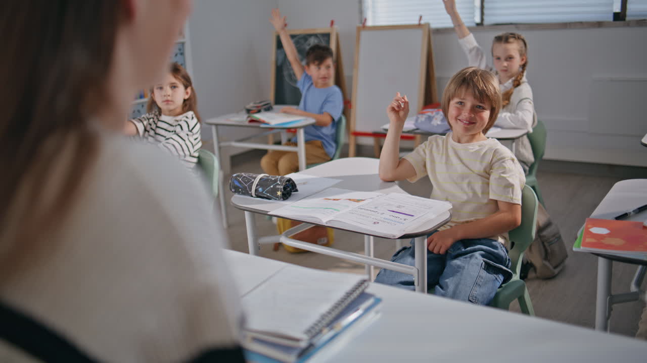 Smart kids raising hands at lesson. Teacher talking pupils explaining at school