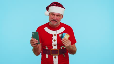 man in christmas red tshirt use mobile cell phone plastic credit bank cards win calebrate wow
