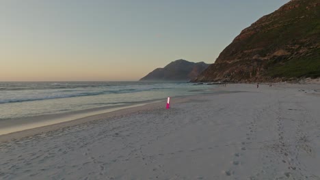 Fast-flyaway-drone-shot-of-a-pink-mirror-on-Noordhoek-beach