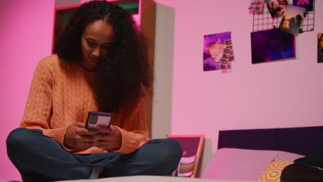 teenage girl using smartphone in bedroom