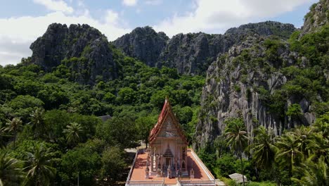 Imágenes-Aéreas-Hacia-El-Templo-Budista-Desde-Una-Gran-Altura-Que-Revelan-Cocos,-Montañas-De-Piedra-Caliza,-Bosques-Y-Cielo