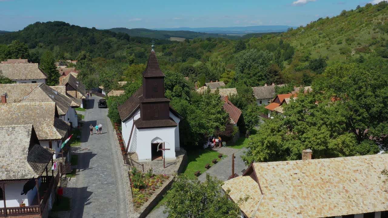 Dron letí odpoledne nad historickými ulicemi Hollókő v Maďarsku.