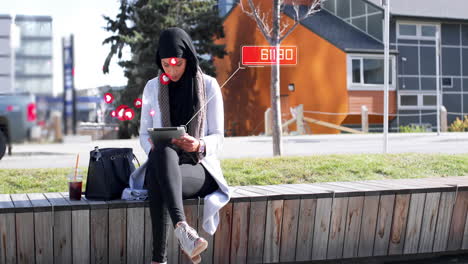 animación de una mujer biracial con hijab y usando una tableta con un número creciente