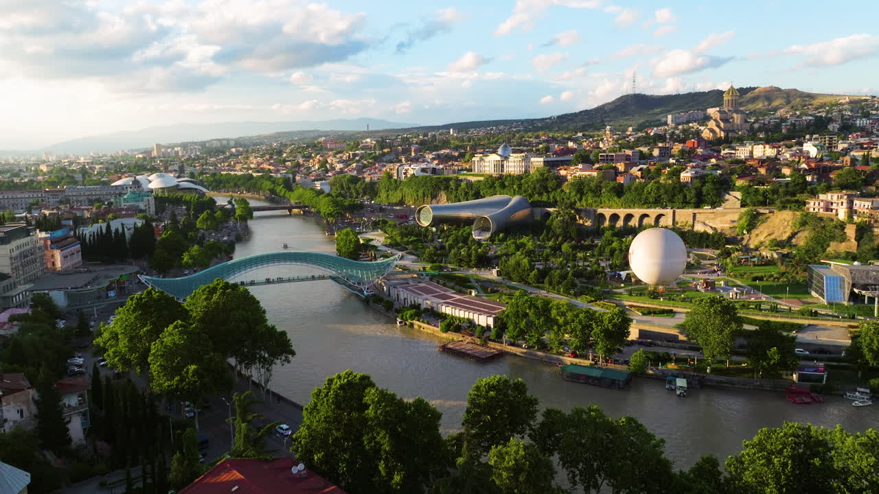 City Landmarks Of Tbilisi With The Bridge of Peace At Sunset In Georgia. Aerial Drone Shot